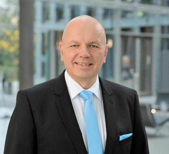 Porträt eines Versicherungsberaters im Anzug mit hellblauer Krawatte